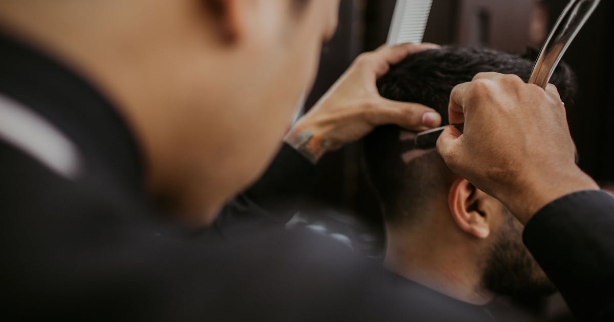 Barbero aplicando técnica de corte moderno